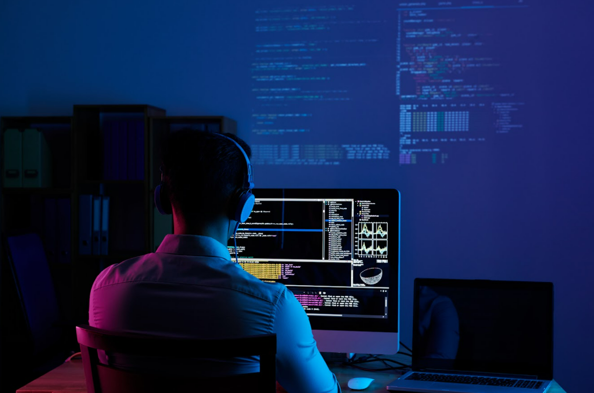 Developer desk with multiple monitors and code