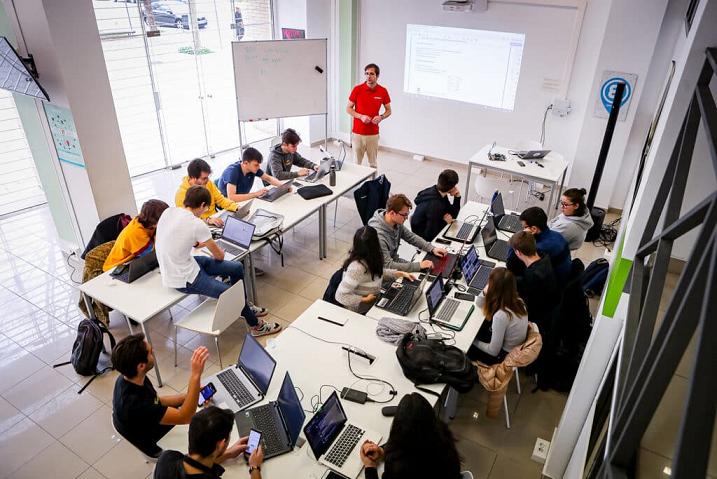 Group of people working around laptops in a bright office